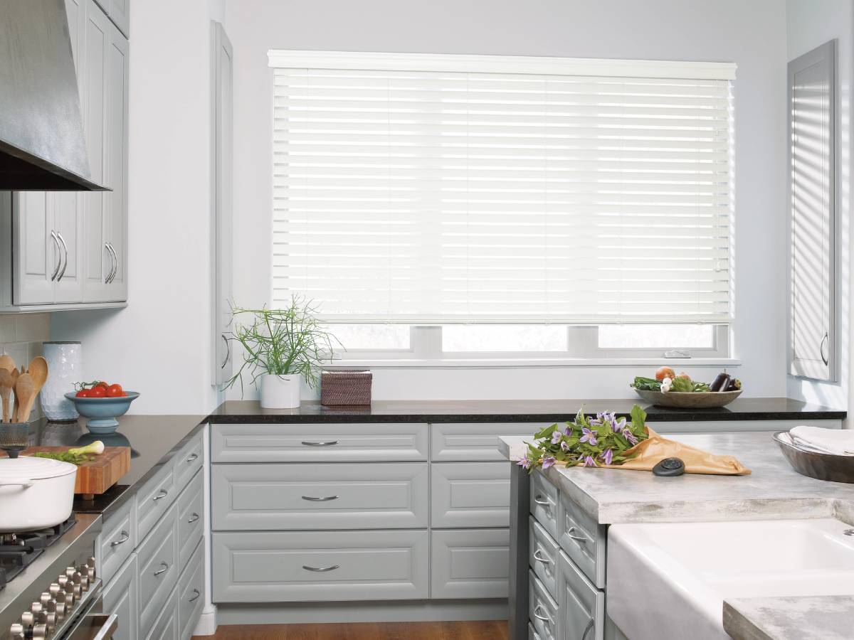 Hunter Douglas Powerview Motorization 7 Hunter Douglas Everwood® Faux Wood Blinds covering a kitchen window.